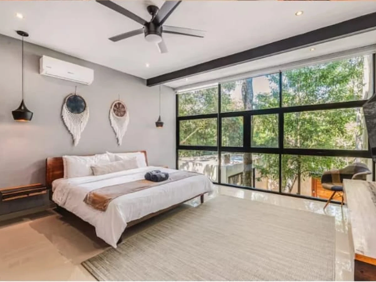 Bedroom with a wall of windows onto the trees